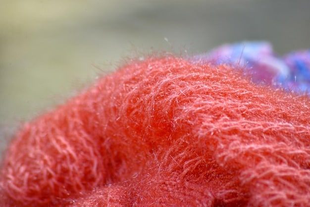 A close-up shot of various fabric textures, including merino wool, cotton, fleece, and nylon, showcasing the differences in breathability and weather-resistance.