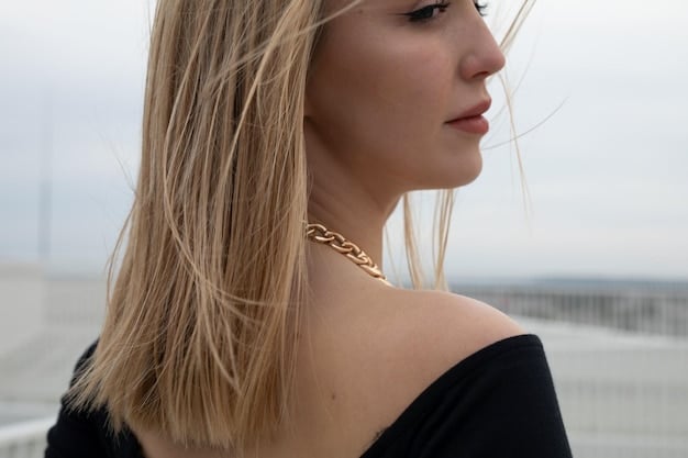 A close-up shot of a woman in the US wearing layered gold necklaces, a delicate bracelet, and minimalist earrings, showcasing the current trend of layered jewelry.