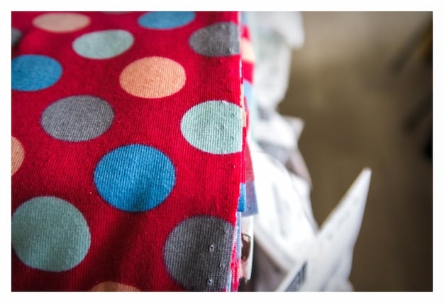 A close-up shot featuring various fabric swatches showcasing different print types: stripes, polka dots, floral patterns, and geometric shapes. The image emphasizes the textures and details of each print.
