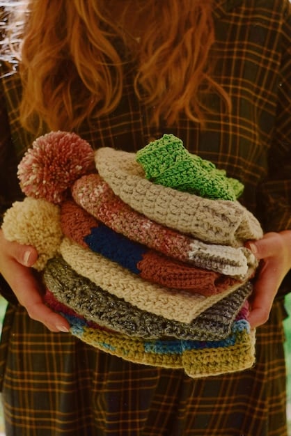 A close up shot of someone's hands digging through a pile of clothing at a thrift store, showing the activity of searching for vintage items. The lighting in the store is functional and bright.