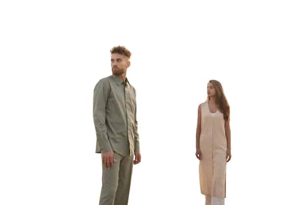 A split image showing two people under the sun. One is wearing light-colored clothing (white or beige), and the other is wearing dark-colored clothing (black or navy). An arrow indicates how light colors reflect sunlight, while dark colors absorb it.