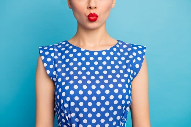 A close-up shot of a woman's outfit, showcasing the successful mixing of a small-scale polka dot top with a larger-scale paisley skirt. The common color thread is teal, which appears in subtle variations in both prints.