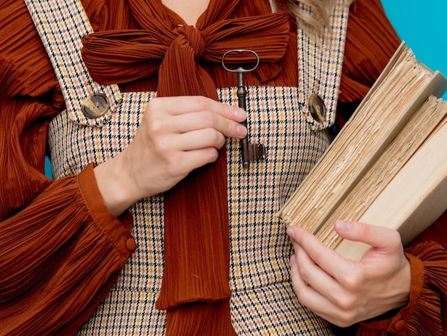 Close-up shot of a person inspecting the seams and fabric of a vintage dress in a dimly lit but organized vintage shop, highlighting details to check for quality.