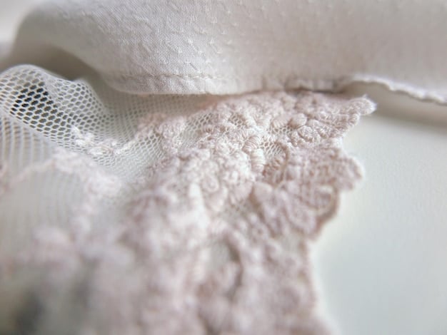 A collage showcasing different types of fabrics commonly used in undergarments, including cotton, lace, silk, and microfiber, with labels indicating their respective textures and properties.