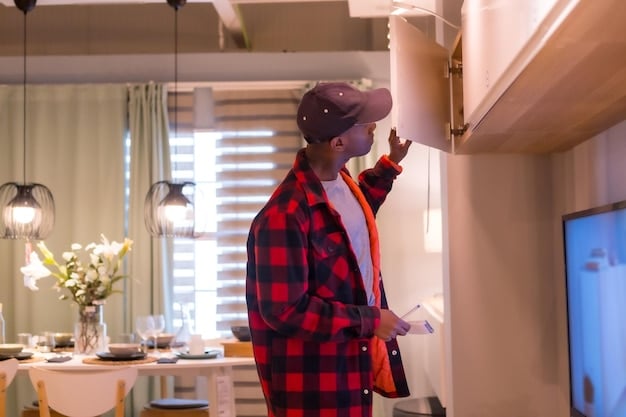 A professional electrician installing smart recessed lighting in a kitchen ceiling, demonstrating the integration of the lighting system with a smart home hub. The kitchen is modern and well-lit, reflecting the benefits of the upgrade.
