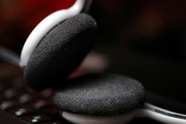Close-up of the earcup of a noise-canceling headphone, highlighting the intricate details of the speaker grill and cushioning. The background is blurred to emphasize the headphone.