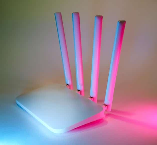A close-up of a Wi-Fi router with various blinking lights. A hand is reaching towards the router, as if about to press the reset button. In the background, a blurred image of a computer screen showing router settings with options for security protocols and password configurations.