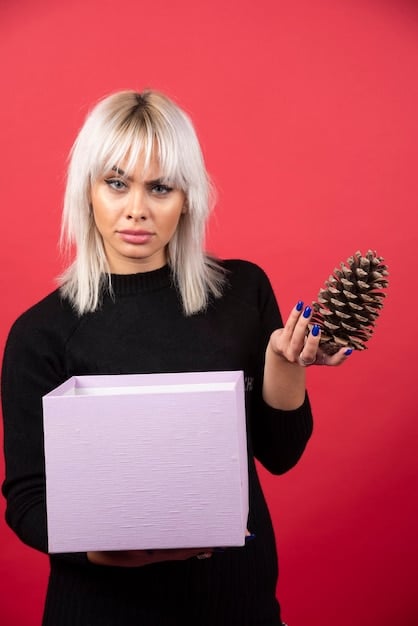 A person holding up an unflattering or unusual clothing item from a SHEIN mystery box, with a slightly disappointed expression. The background is a bedroom, adding a personal touch to the image.