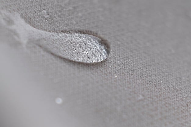 A detailed fabric swatch showing a moisture-wicking material with visible micro-perforations under a magnifying glass, symbolizing breathability.