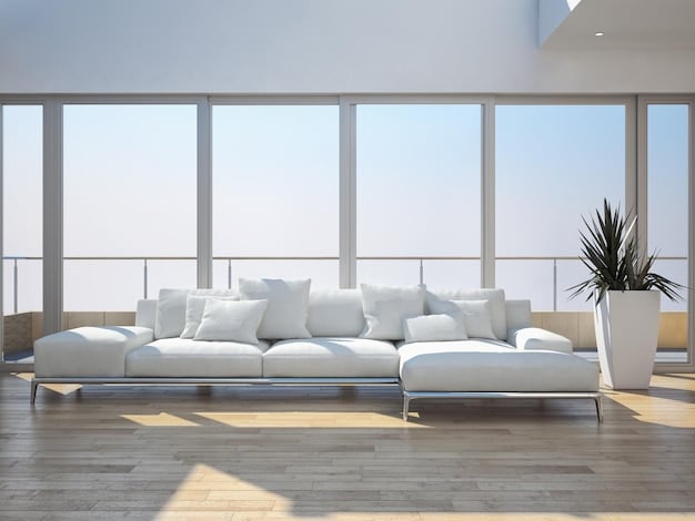A modern living space featuring a large smart window that is partially tinted to reduce glare, showing a clear blue sky outside.